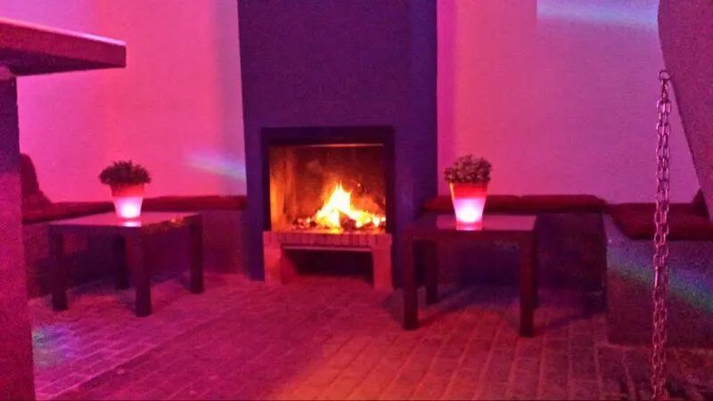 Rincón con chimenea encendida y luz rosa